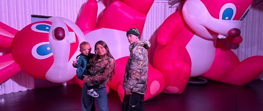 Family with children before large pink rabbit sculptures